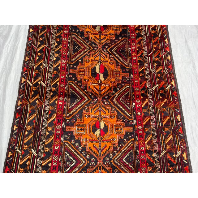 This exceptional vintage Afghan hand-knotted wool rug displays a powerful tribal geometric medallion design in vibrant...