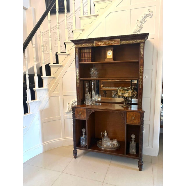 A fine antique Regency rosewood open bookcase of elegant proportions, decorated with intricate brass inlay throughout and...