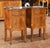 Crafted in France circa 1880, this elegant pair of antique Louis XV-style bedside tables features richly figured walnut...