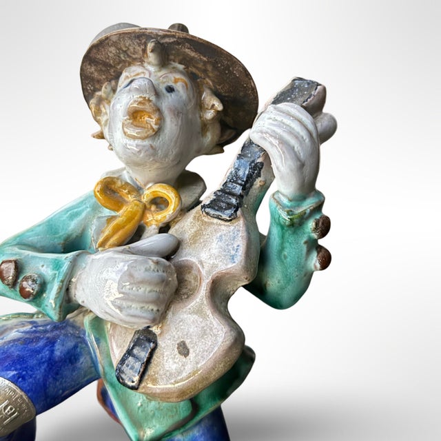 This vintage ceramic musician figurine, inspired by the work of Austrian artist Leopold Anzengruber (1912–1979), is a...