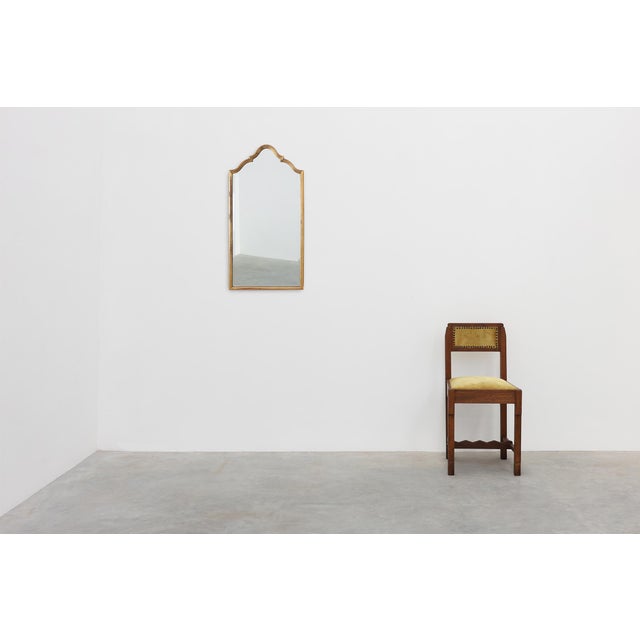 A striking French wall mirror from the early 20th century, distinguished by its elegant ogee-arched silhouette inspired by...