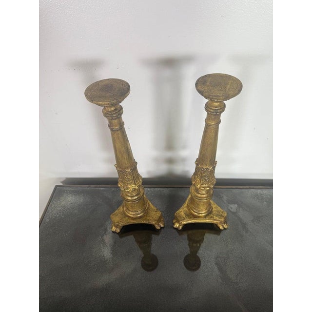 A refined pair of antique giltwood candlesticks showcasing elegant Neoclassical influence. Each candlestick features a...