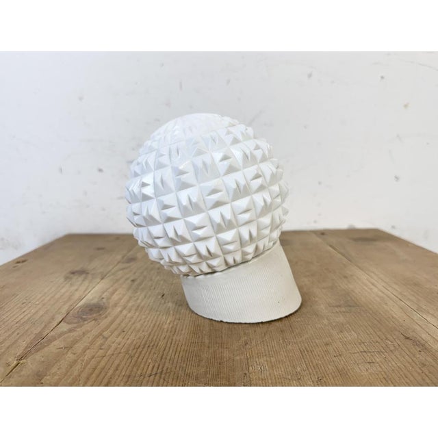 Vintage industrial light made in former Czechoslovakia the 1970s. It features a white porcelain wall mounting and a milk...