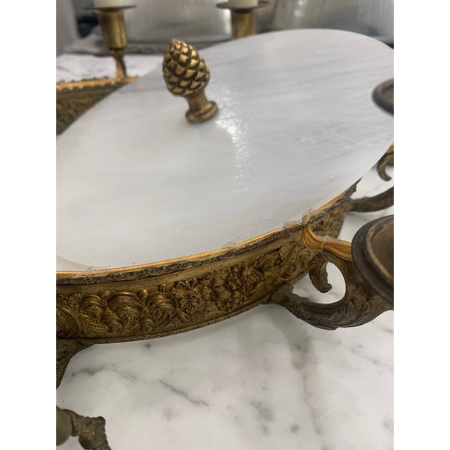 5 electrified candle arms issuing from an ornamented metal ring hung with crystal beaded swags and drop pendants. The ring...