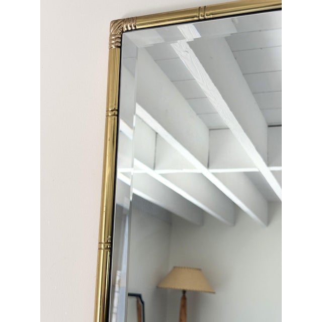 A vintage wall mirror with a brassed metal frame emulating bamboo. This original mid century rectangular mirror has a...