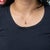 This solid 14K yellow gold pendant centres a 1.03-carat oval padparadscha sapphire, haloed by thirty-five earth-mined...