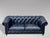 A good quality mid 20th-century three seater black leather chesterfield with two large loose cushions, raised on turned...