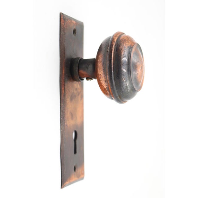 Vintage dummy set with a japanned finished brass knob with concentric face detailing on a flat steel plate. The original...