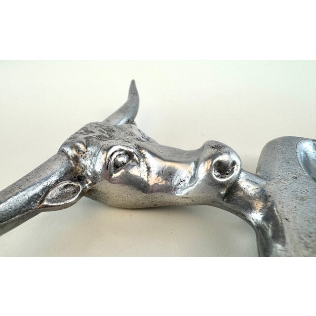 A distinctive vintage cast aluminum carving fork fashioned as a Texas longhorn steer, with an expressive modeled head,...