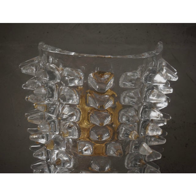 This clear Murano glass wall light features a refined and delicate design. The wall light features a brass structure that...