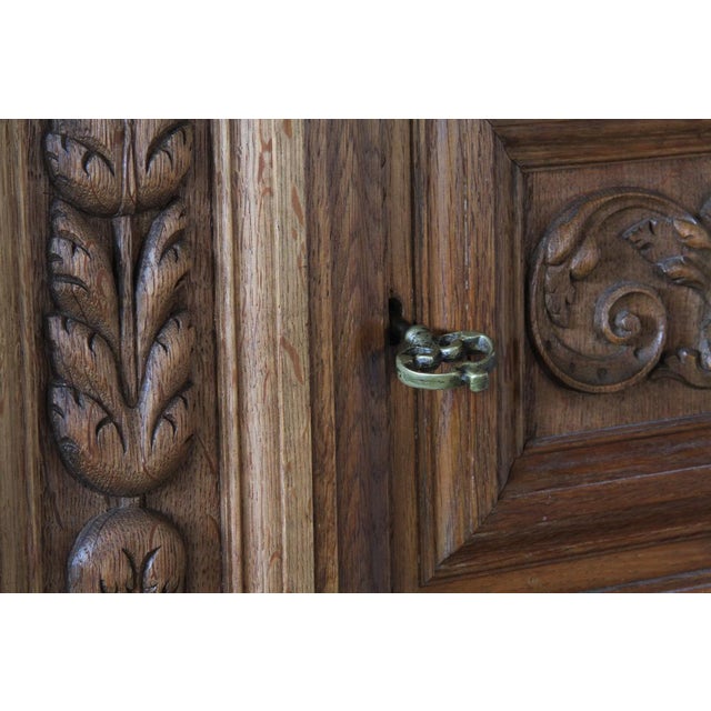 A stunning piece, featuring intricate hand-carved patterns on its front panels in the style of Victorian English oak...
