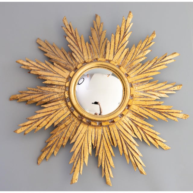 A beautifully carved French giltwood sunburst mirror with the original convex glass, circa 1950. The lovely gilt patina...