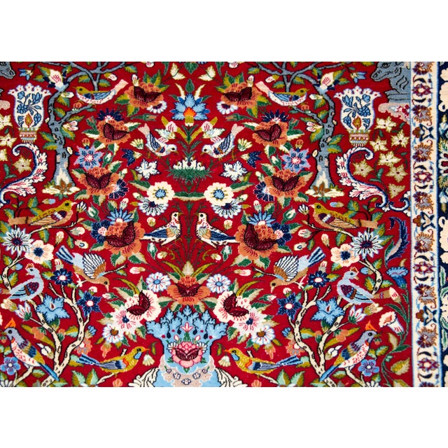 A wonderful late 20th century Persian Isfahan rug with a large central vase sprouting a tree-of-life with myriad flowers...