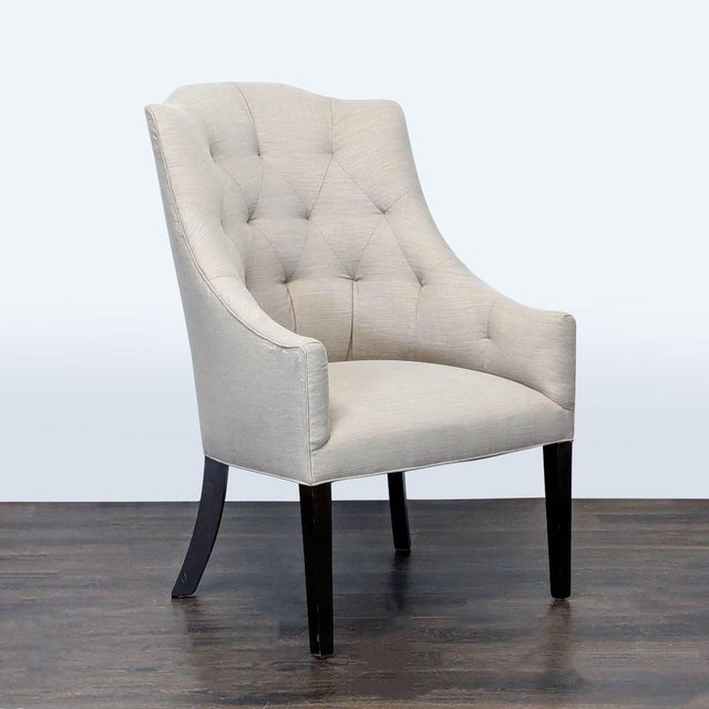 This Cisco Bros lounge chair features a stylish tufted back design and soft light beige upholstery. The gently curved arms...