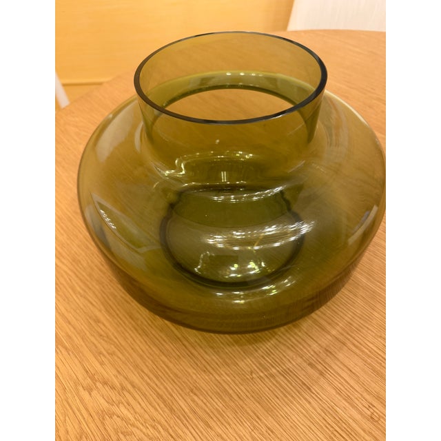 Marimekko's olive-green "Urna" is a beautiful, cylinder-shaped vase designed by Carina Seth Andersson and is made of...
