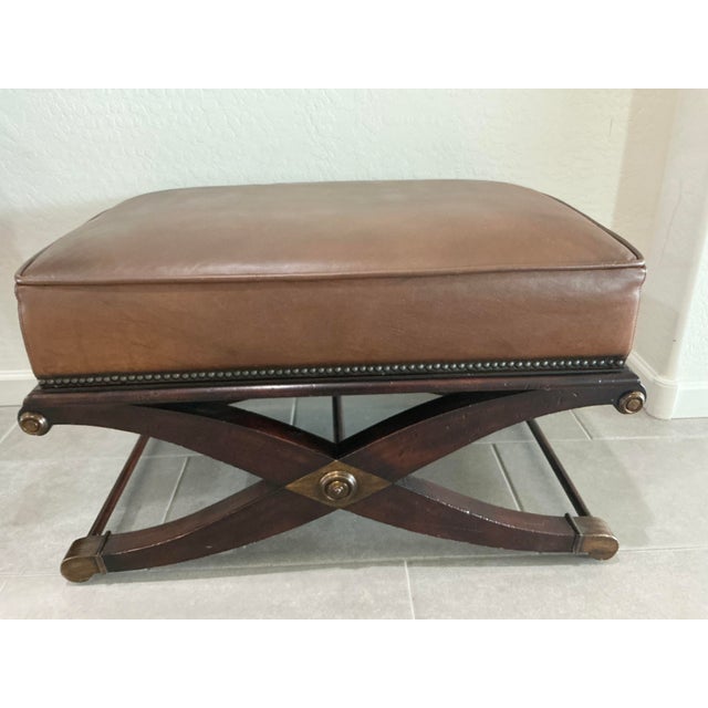 Baker Spanish Savonarola style bench with brown leather top over an X-form base, 20th Century. Height: 19 in. Width: 32...