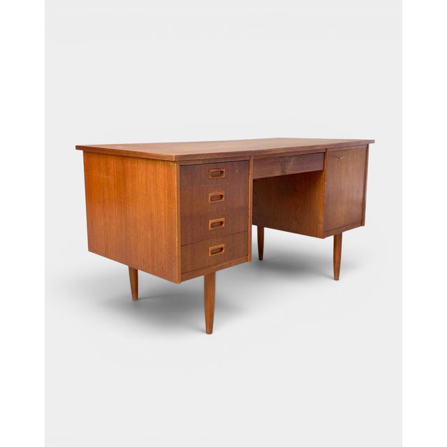 Classic Danish desk from the 1960s, finished in teak veneer. Its clean, elegant form, slender tapered legs and...