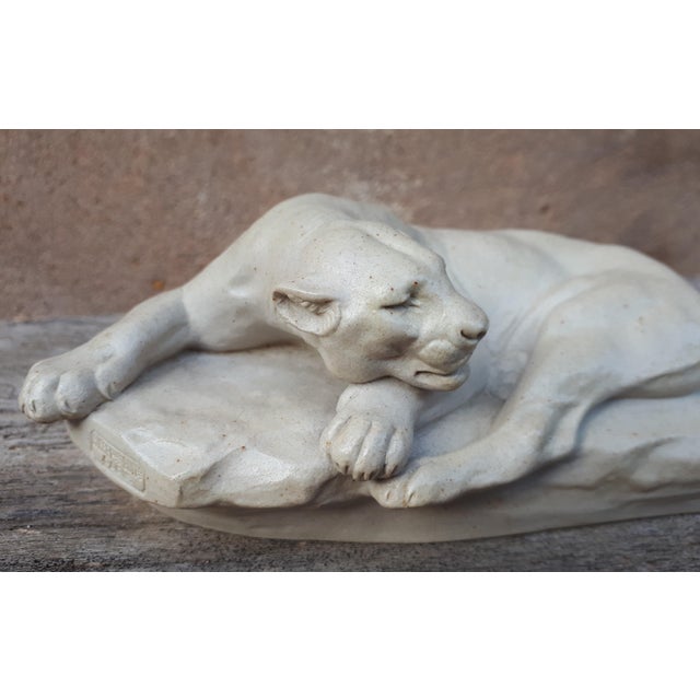 Superb enameled sandstone animal sculpture representing a lioness lying on a rock. Bears the artist's signature "c.masson"...