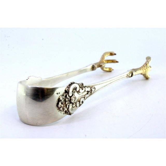 Silver Ice Tongs with Gold-Colored Claws, Raised Temples and Grooves, in Very Good conditions. Designed 1920 to 1949 This...