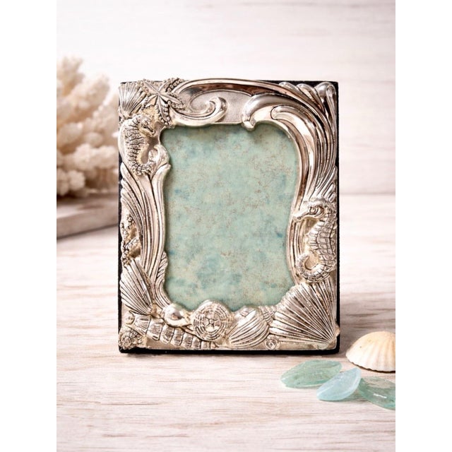 A sculptural vintage Godinger silverplate picture frame decorated with dimensional seahorses, scallop shells, starfish and...