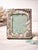 A sculptural vintage Godinger silverplate picture frame decorated with dimensional seahorses, scallop shells, starfish and...