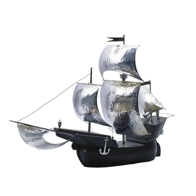 A handcrafted sculpture depicting an ancient sailing ship, perfect as a sophisticated piece of décor or a collector’s...