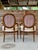 A handsome pair of antique Louis XVI style fauteuil armchairs featuring elegant oval backs, scrolling arms, carved rosette...