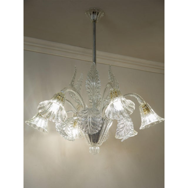 An elegant 1940s Murano blown glass chandelier, crafted in the prestigious Barovier & Toso furnaces. The central structure...