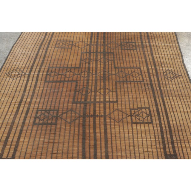 This vintage Moroccan mat is a primitive 6x7 Tuareg work from the nomadic tribe of the same name. Handwoven with reeds and...