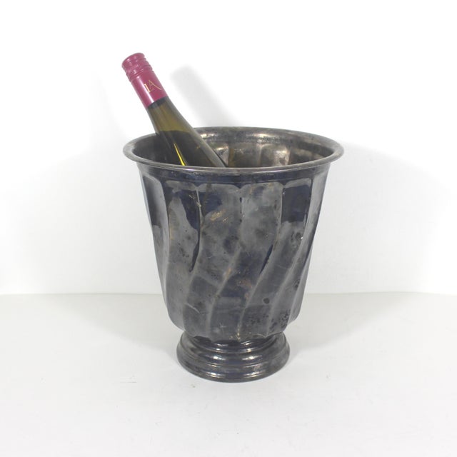 This is a large elegant silver plated ice bucket with a swirl pattern. This bucket has some heavy patina or tarnish on the...