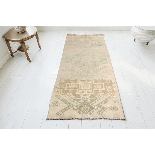 This is a vintage Turkish Oushak rug from the Mid 20th Century. The piece was hand-knotted.