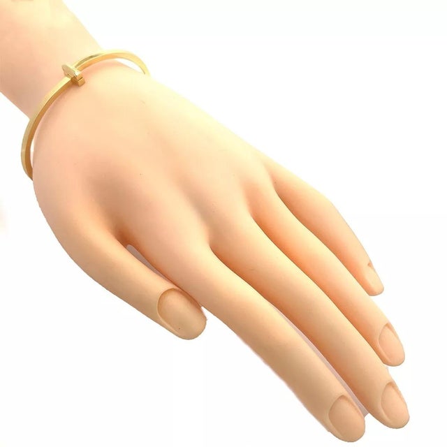 This elegant authentic bracelet is by Tiffany & Co. from the Tiffany T1 Collection. 18k yellow gold wrapped around the...