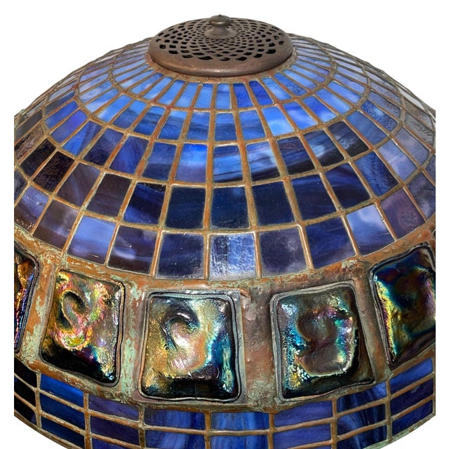 Fine Tiffany Studios table lamp featuring a dark patinated bronze base and a domed leaded-glass shade in rich blue...