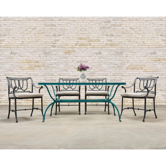An elegant set of four cast aluminum garden armchairs crafted in the manner and style of Brown Jordan. Each chair features...
