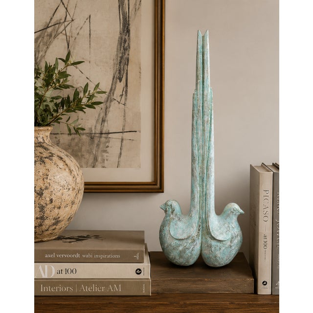 A distinctive sculptural accent featuring two stylized doves seamlessly joined in a striking symmetrical composition....