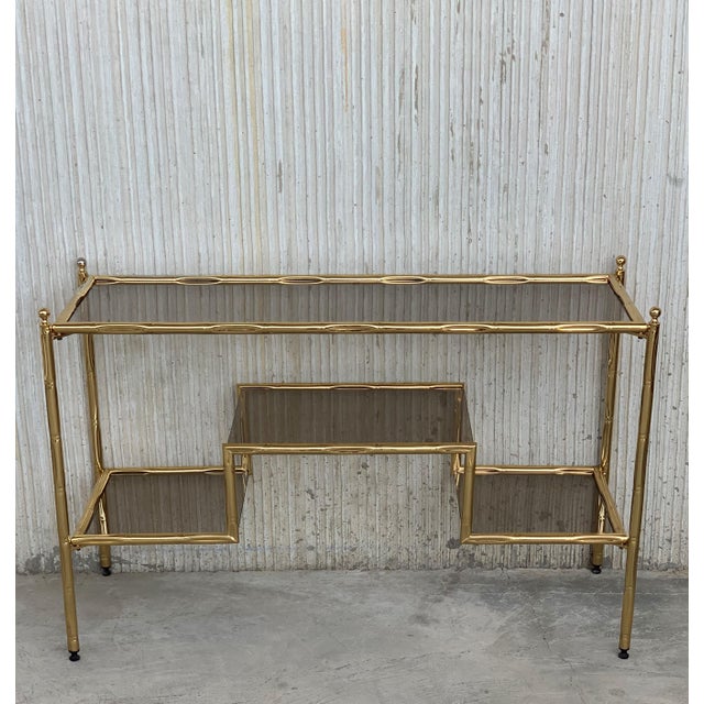About Mid-Century Modern Italian Faux Bamboo Gilt Metal Console Table or Vanity with Smoked Glass Total Height: 25.6in...