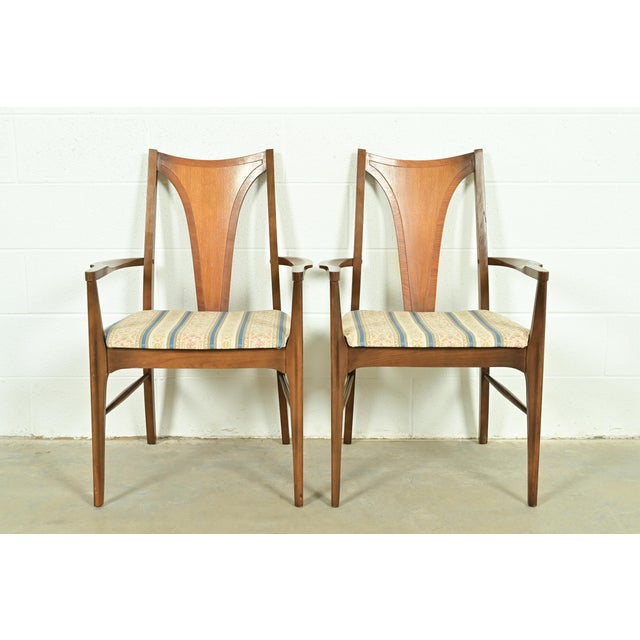 A gorgeous pair of Mid-Century Modern armchairs or dining captain chairs By Broyhill Brasilia USA, 1960s Sculpted walnut...