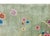 This hand-woven Chinese Art Deco wool rug from the 1940s features a vibrant array of floral motifs scattered across a...