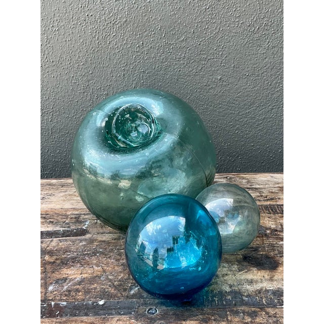 This curated set of five vintage hand-blown glass fishing floats captures the serene beauty and history of the sea....
