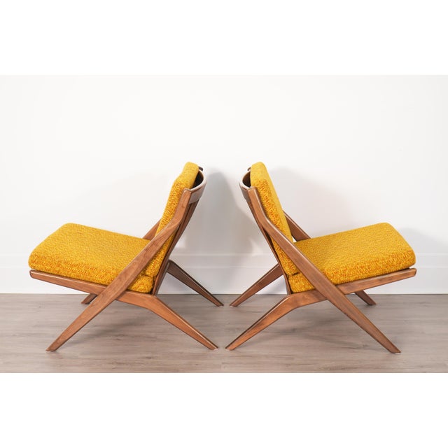Pair of Folke Ohlsson scissor lounge chairs for DUX, made in Sweden during the 1950s–1960s. The chairs feature solid beech...