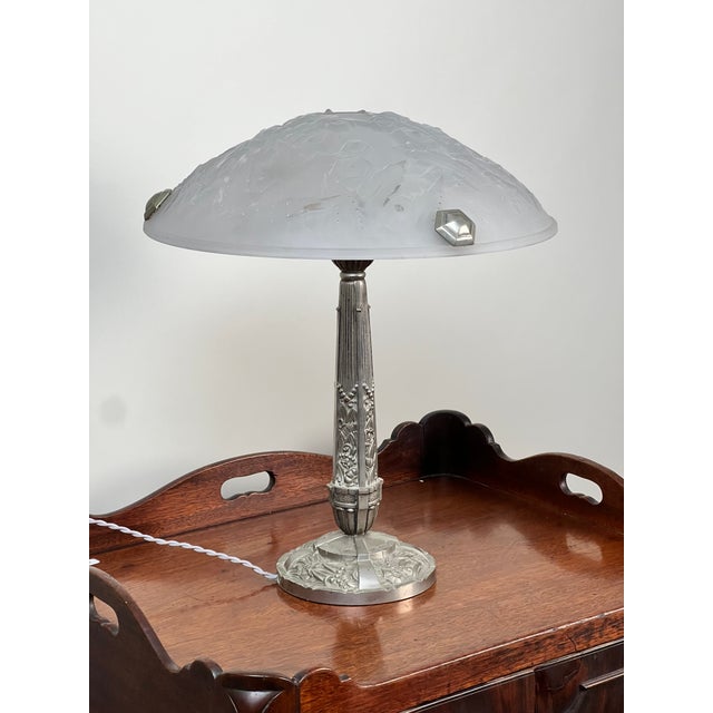 A striking example of French Art Deco lighting, this elegant table lamp features a beautifully molded frosted glass shade...