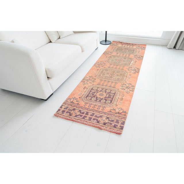 This is a vintage Turkish Oushak rug from the Mid 20th Century. The piece was hand-knotted.