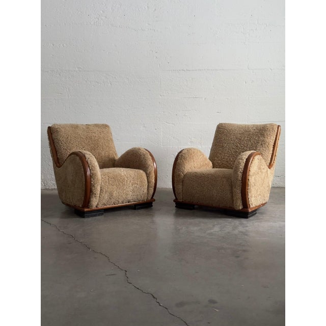 A substantial pair of Danish Art Deco easy chairs from the 1930–40 period, newly upholstered in caramel sheepskin with...