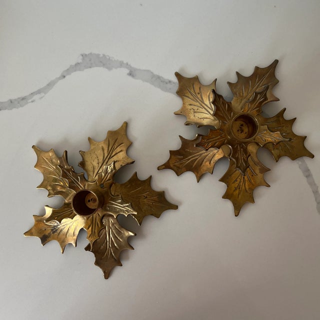 Pair of brass holly candlestick holders perfect for holiday or winter decor.