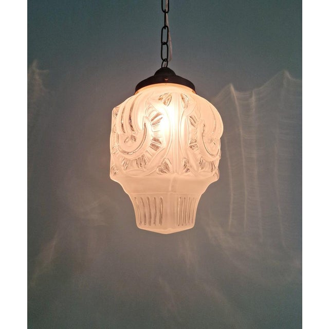 Art Deco pendant light with a frosted molded pressed glass globe and a copper-plated metal frame, 1920s-30s. This pendant...