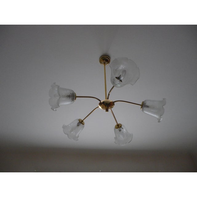Gold-tone metal chandelier with five arms, giving it a "space age" style. Five corolla-shaped lights in opaque glass with...