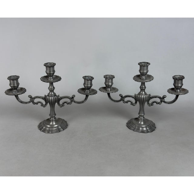 A refined pair of three-light table candelabras, crafted from solid vintage pewter and featuring original foundry marks...