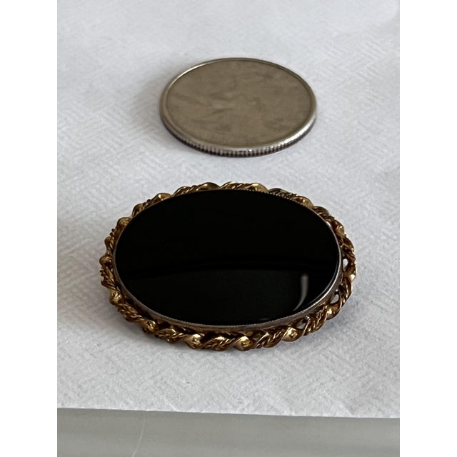 Vintage costume jewelry brooch with a polished oval cabochon center stone having a tortoiseshell pattern. It was engraved...