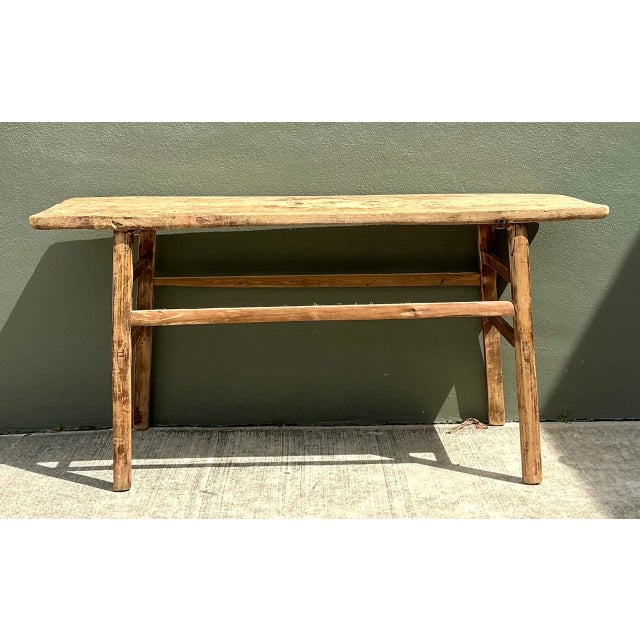 Crafted with a minimalist, functional silhouette, this vintage console table is built from solid wood featuring a warm,...
