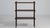 A mid-century modern etagere with open shelves and a slim vertical frame. The design allows for display without visual...